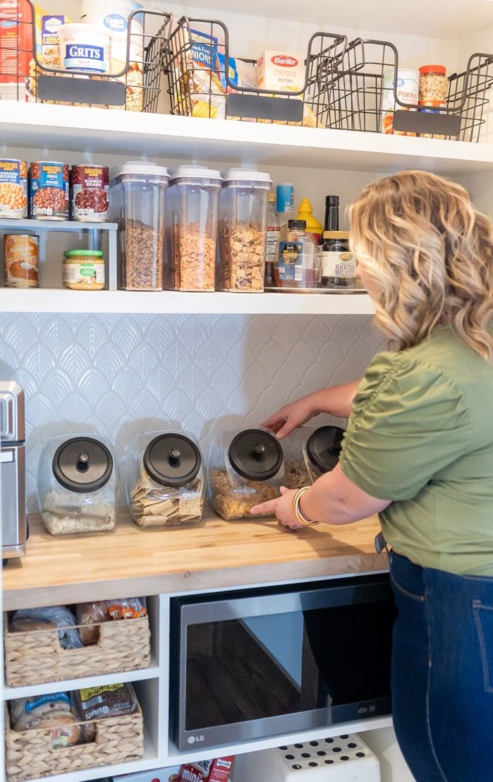 a woman is organizing a home pantry